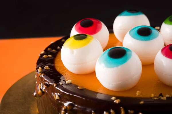 Pastel Halloween Con Decoración Ojos Caramelo Sobre Fondo Naranja Negro — Foto de Stock