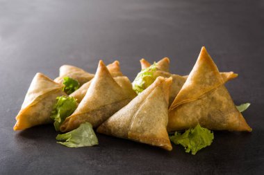Samsa veya samosas siyah arka plan üzerinde et ve sebze ile. Geleneksel Hint yemekleri. 