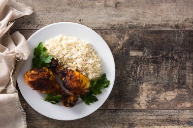 Tahta masa üzerinde tabakta basmati pirinç ile kavrulmuş tandır tavuk. Üst te. Kopyalama alanı