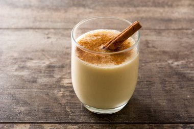 Ahşap masada cam tarçın ile ev yapımı eggnog. Tipik Noel tatlısı. 