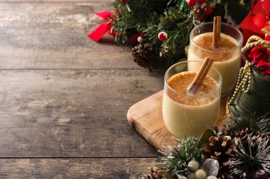 Ahşap masada cam tarçın ile ev yapımı eggnog. Tipik Noel tatlısı. Kopyalama alanı
