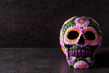 Siyah arka plan üzerine boyanmış çiçekleri olan tipik Meksika kafatası. Dia de los muertos. Kopyalama alanı