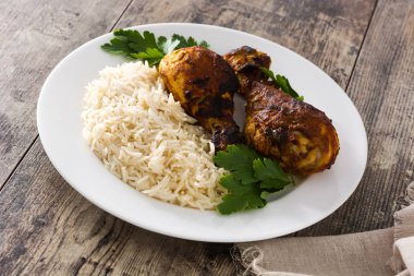 Ahşap masa üzerinde tabakta basmati pirinç ile kavrulmuş tandır tavuk.