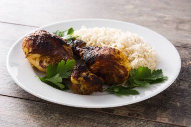 Ahşap masa üzerinde tabakta basmati pirinç ile kavrulmuş tandır tavuk.