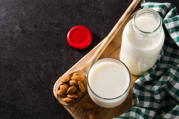 Bio Mandelmilch Glas Und Flasche Auf Schwarzem Hintergrund — Stockfoto