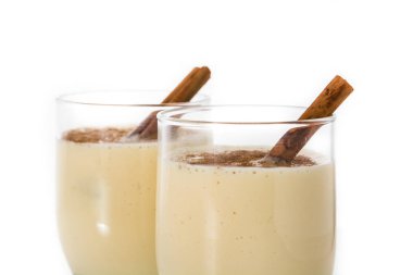 Beyaz arka plan üzerinde izole cam tarçın ile ev yapımı eggnog. Tipik Noel tatlısı.