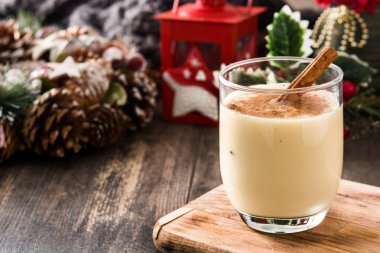 Ahşap masada cam tarçın ile ev yapımı eggnog. Tipik Noel tatlısı. Kopyalama alanı