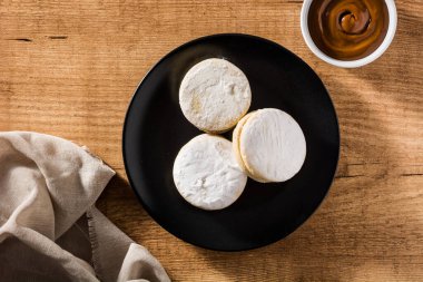 Geleneksel Arjantin alfajorleri. Dulce de leche ve ahşap masa üzerinde şeker. Üst görünüm