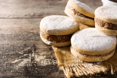 Geleneksel Arjantin alfajorleri. Dulce de leche ve ahşap masa üzerinde şeker. Boşluğu kopyala