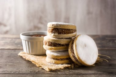 Geleneksel Arjantin alfajorleri. Dulce de leche ve ahşap masa üzerinde şeker.