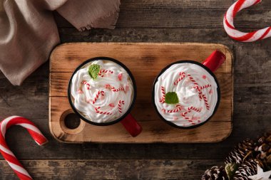 Noel 'de tahta masanın üzerinde şeker kamışlarıyla süslenmiş nane aromalı kahve. Üst görünüm