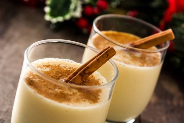 Ahşap masada cam tarçın ile ev yapımı eggnog. Tipik Noel tatlısı. 