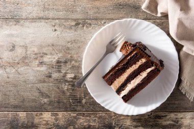 Tahta masada çikolatalı pasta dilimi. Üst Manzara. Boşluğu kopyala