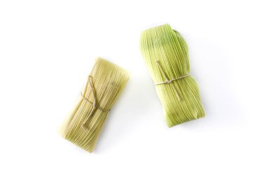 Beyaz arka planda Meksika mısırı ve tavuk tamalesi.