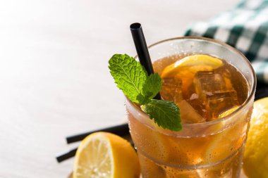 Buzlu çay, bardakta limon ve beyaz tahta masada buz.
