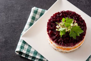 Siyah arka planda pancar kökü ve havuçlu geleneksel Rus ringa salatası. Boşluğu kopyala.