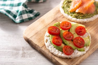 Tahta masada avokado ve domatesli pirinç keki.