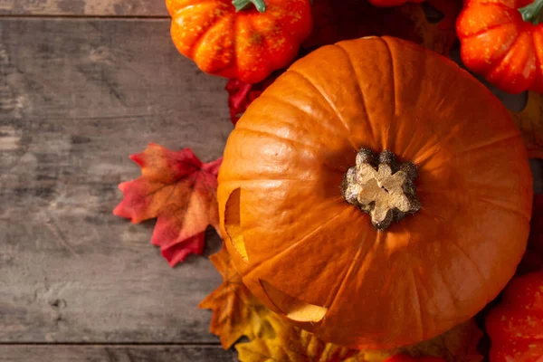 Cadılar Bayramı balkabağı ve sonbahar yaprakları ahşap masada. Üst Manzara. Boşluğu kopyala