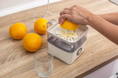 Mutfakta portakal sıkan kadın.