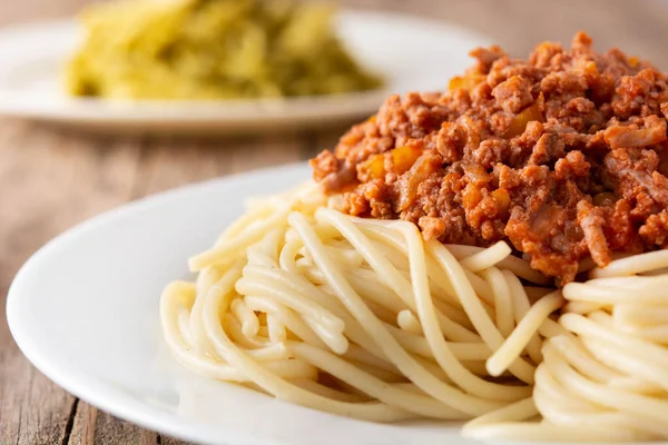 Spaghetti with bolognese sauce on wooden table