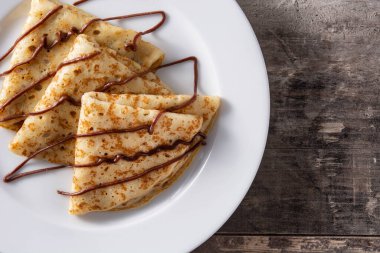 Tahta masa üzerinde çikolatalı krep. Manzaralı. Boşluğu kopyala