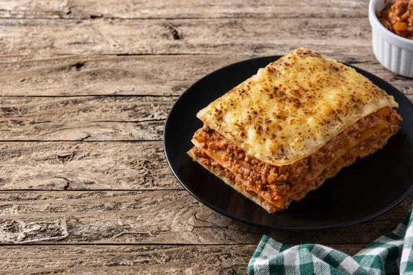 Fleischlasagne Auf Schwarzem Teller Auf Rustikalem Holztisch Kopierraum — Stockfoto