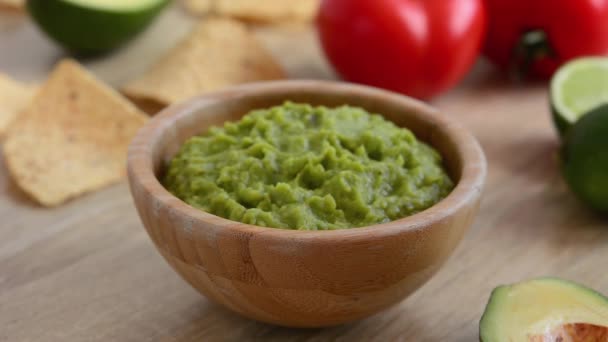 Mulher Mergulhando Com Chip Nacho Molho Guacamole Mesa Madeira — Vídeo de Stock