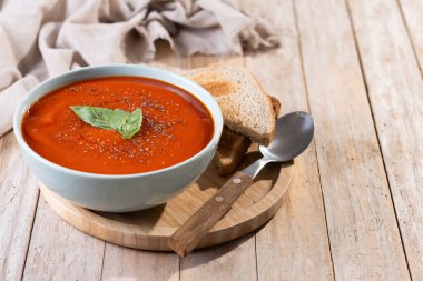 Ev yapımı domates çorbası ve ahşap masada fesleğen. Boşluğu kopyala