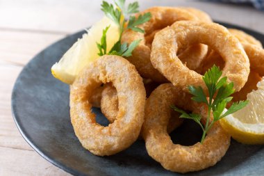 Ahşap masada kızarmış kalamar halkaları.