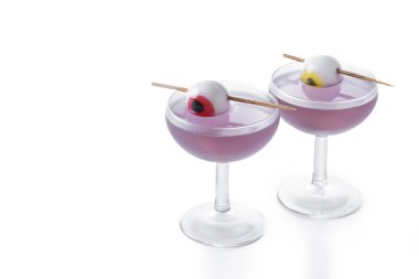 Mor Cadılar Bayramı kokteyli, beyaz arka planda izole edilmiş şeker gözlerle süslenmiş. Boşluğu kopyala