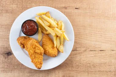 Tahta masada kızarmış patates kızartması ve kızarmış tavuk. Üst Manzara. Boşluğu kopyala