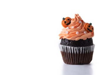 Beyaz arka planda turuncu tereyağlı ve balkabağı süslemeli Cadılar Bayramı kekleri. Boşluğu kopyala