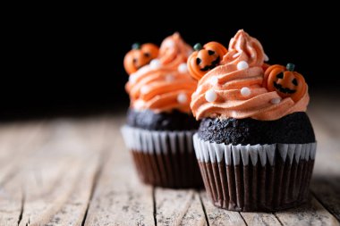 Kabak süslemeli Cadılar Bayramı çörekleri kırsal ahşap masa ve siyah arka plan