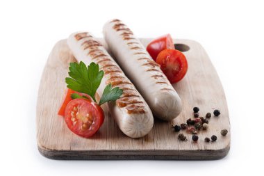 Kızarmış sosis, kiraz domatesli ve maydanozlu beyaz arka planda.