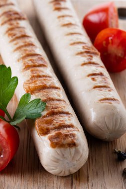 Kızarmış sosis, kiraz domatesli ve maydanozlu. Kapat.