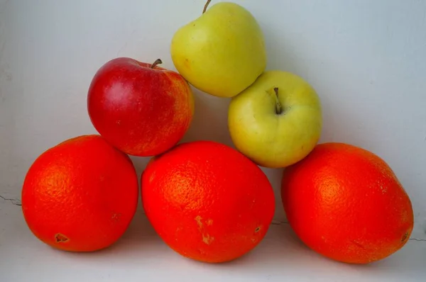 Elmalar ve portakallar ışık arka plan üzerinde.