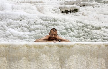 Pamukkale. Turkey.June 7, 2018.A adam termal kaynakları ve Traverten Pamukkale Havuzda yüzüyor.