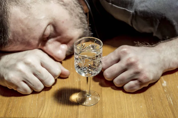 L'uomo si è addormentato ubriaco al tavolo davanti a un bicchiere di vo — Foto Stock