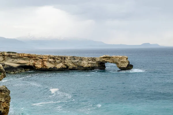 Rock in the form of a stone arch on the coast of Crete in the Me — Stock Photo, Image