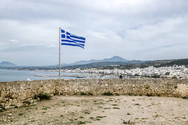 La bandera griega ondea en la pared de la fortaleza veneciana en — Foto de Stock