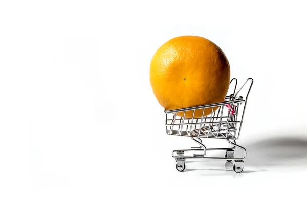 オレンジは白い背景におもちゃの食料品店のカートに横たわっています — ストック写真