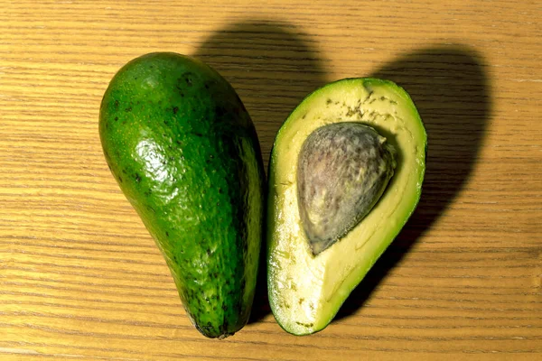 Snijd Avocado Plakken Liggen Een Houten Oppervlak — Stockfoto