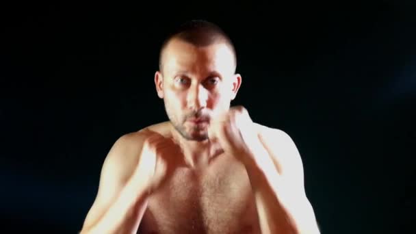 暗い背景に裸の胴箱を持つ戦闘姿勢の男 — ストック動画