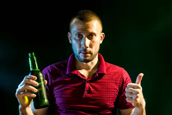 Uomo Beve Felicemente Birra Una Bottiglia Uno Sfondo Verde Scuro — Foto Stock