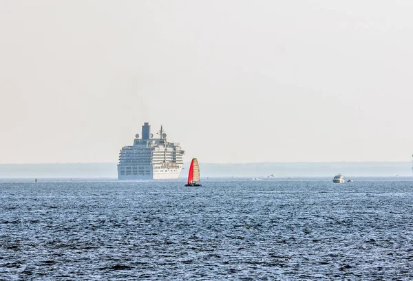 Vela Roșie Unui Iaht Fundalul Unei Nave Croazieră Uriașe Marea — Fotografie, imagine de stoc