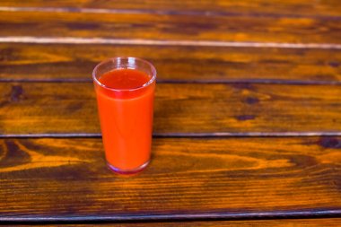 Tahta bir masada cam domates suyu. Sağlıklı organik gıda konsepti.