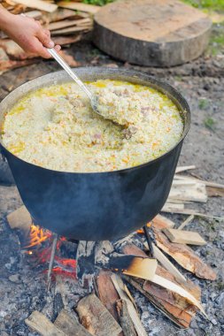 Doğada lezzetli pilav pişirme. Piknikte büyük kazanda pilav pişirmek.