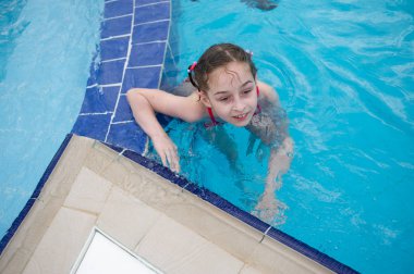 Küçük bir kız yazın su parkında dinleniyor. bebek havuzda yüzer.