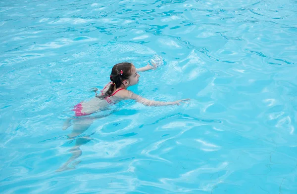Egy kislány pihen a nyáron az Aqua parkban. baba úszik a medencében. — Stock Fotó