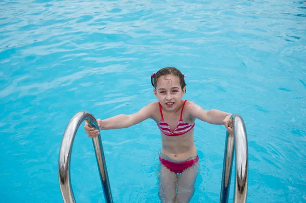 O fetiţă se odihneşte vara în parcul acvatic. Copilul înoată în piscină . — Fotografie, imagine de stoc